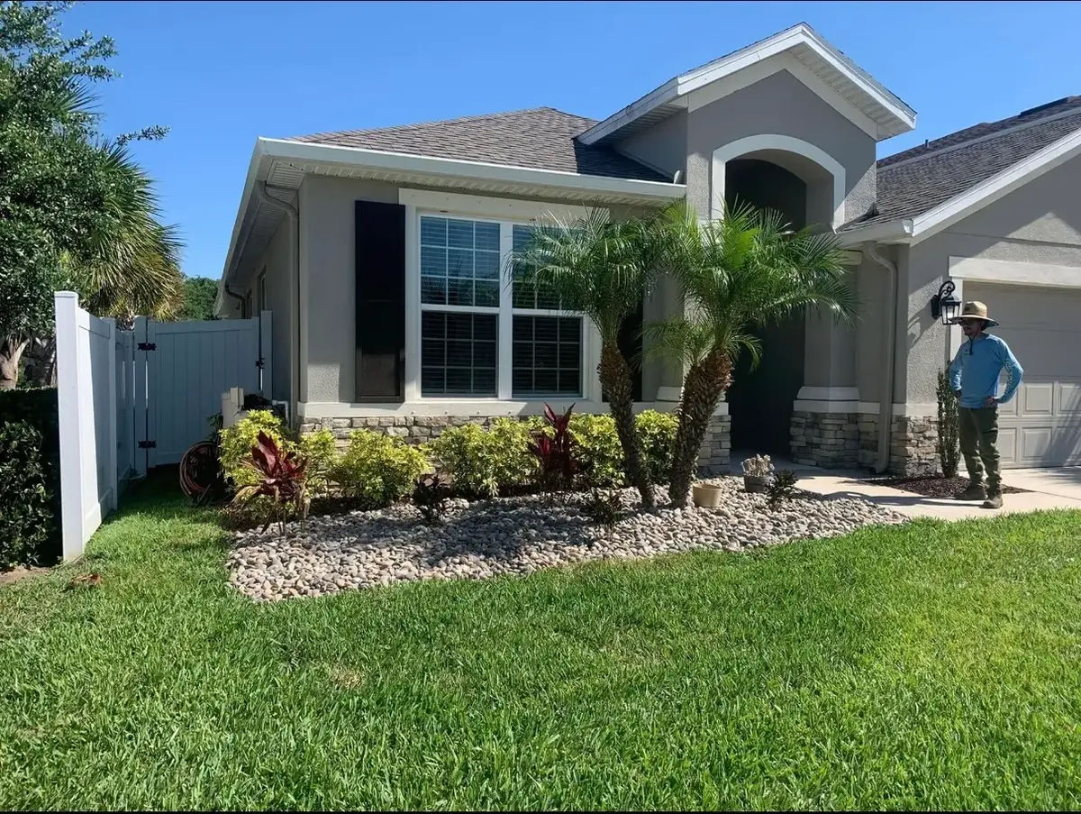 Freshly landscaped front yard with river rock beds and a green lawn
