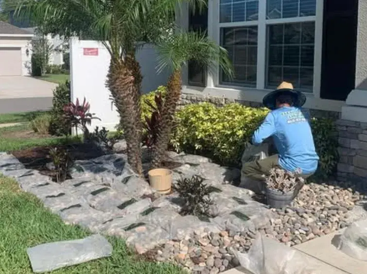 Crew member tending a landscaped rock bed
